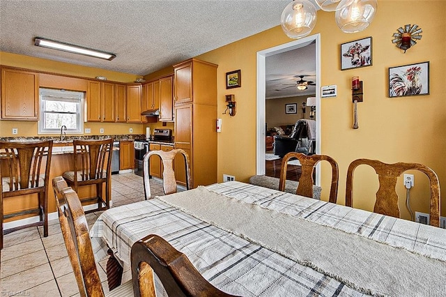 dining room with light tile patterned floors, ceiling fan, and a textured ceiling