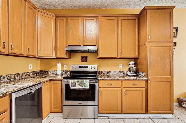 kitchen featuring stone counters, light tile patterned floors, stainless steel range with electric stovetop, under cabinet range hood, and dishwashing machine