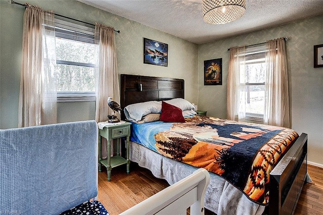 bedroom with a textured ceiling and wood finished floors