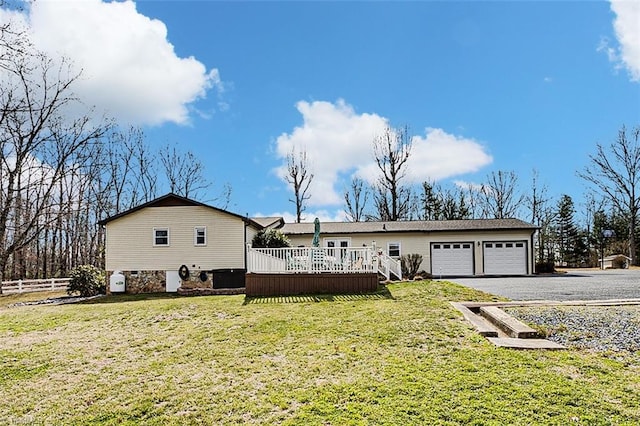 view of front of property with aphalt driveway, a front yard, fence, and an attached garage