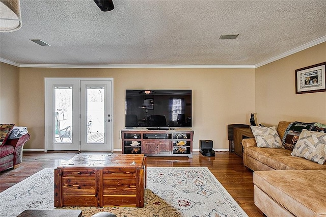 living area featuring baseboards, crown molding, visible vents, and wood finished floors