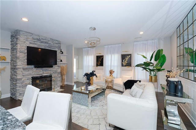 living room with wood-type flooring, a fireplace, and a chandelier