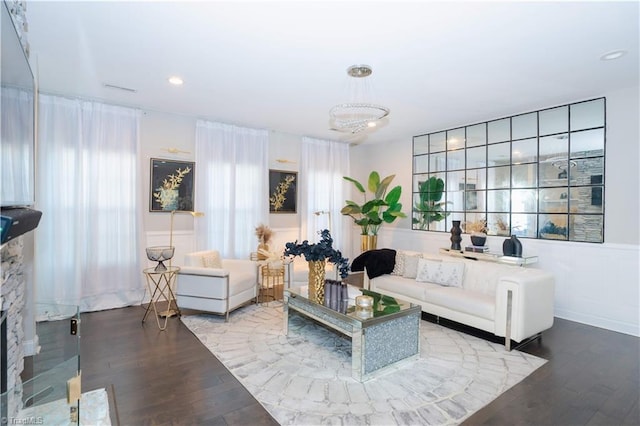 living room featuring a notable chandelier, wood-type flooring, and a fireplace