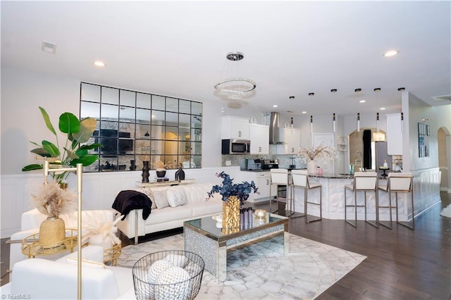 living room with a notable chandelier, dark hardwood / wood-style flooring, and sink