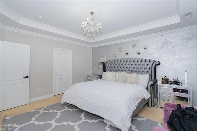 bedroom with a tray ceiling, crown molding, and a chandelier