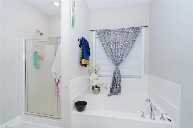 bathroom featuring shower with separate bathtub