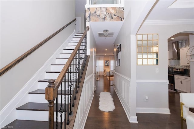 staircase featuring hardwood / wood-style flooring and crown molding