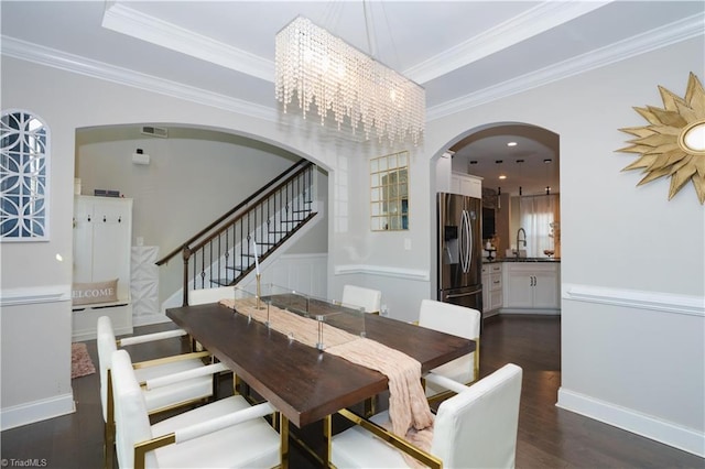 dining area with dark hardwood / wood-style flooring, sink, a chandelier, and ornamental molding