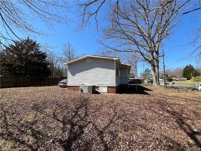 view of side of home with fence and central AC