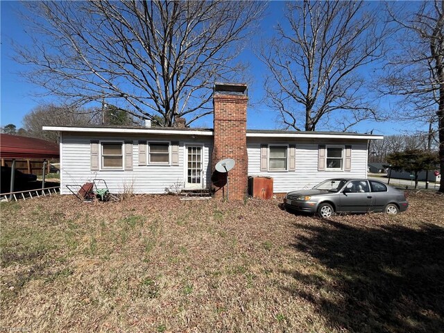 view of front facade with a chimney and a front lawn