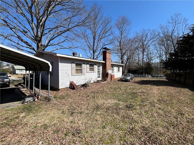 exterior space with a carport and a chimney