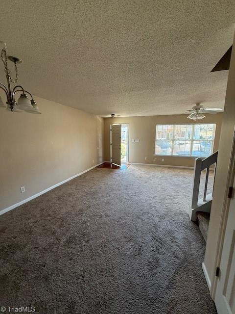 unfurnished living room with ceiling fan, carpet flooring, and a textured ceiling