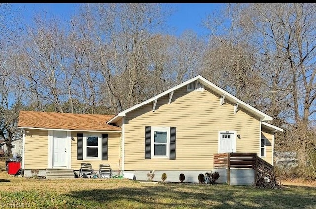 back of house featuring a lawn and entry steps