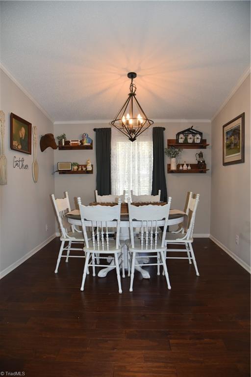 621 Southern Rd, King, NC 27021 - dining space with a chandelier, ornamental molding, and wood finished floors