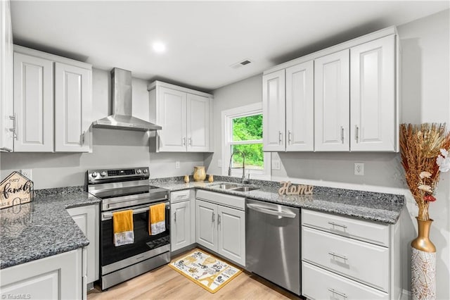 1732 Harrison Ave, Winston-Salem, NC 27105 - kitchen featuring appliances with stainless steel finishes, wall chimney range hood, white cabinets, and light wood-style flooring
