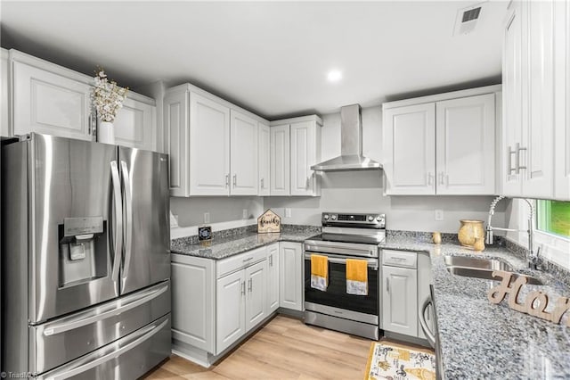 1732 Harrison Ave, Winston-Salem, NC 27105 - kitchen with appliances with stainless steel finishes, wall chimney exhaust hood, white cabinetry, light stone countertops, and recessed lighting