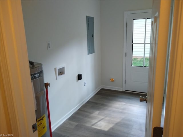 clothes washing area featuring strapped water heater, electric panel, laundry area, hookup for a washing machine, and wood finished floors
