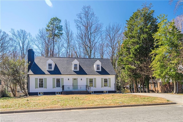 cape cod home featuring a front lawn