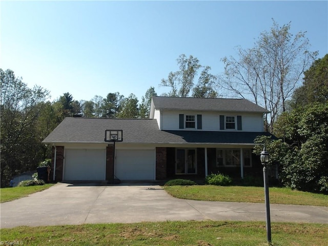 view of property with a garage, a front lawn, and covered porch