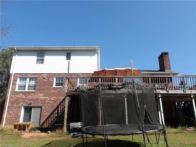 back of house featuring a trampoline and a deck