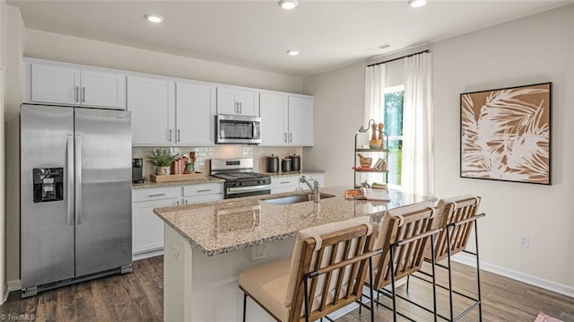 kitchen with white cabinetry, sink, a kitchen island with sink, and stainless steel appliances