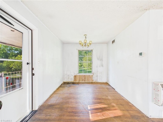 1008 E Brookline St, Winston-Salem, NC 27107 - empty room with wood finished floors, a chandelier, heating unit, and a textured ceiling