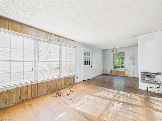 1008 E Brookline St, Winston-Salem, NC 27107 - unfurnished living room with heating unit, wood finished floors, a chandelier, a textured ceiling, and wood walls
