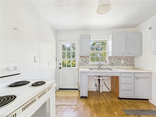 1008 E Brookline St, Winston-Salem, NC 27107 - kitchen featuring white range with electric stovetop, a sink, light wood-style floors, tasteful backsplash, and light countertops
