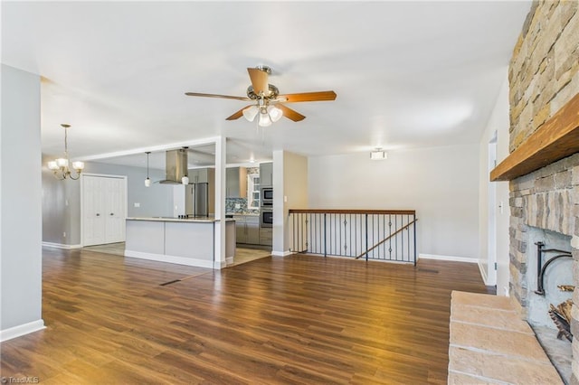 3640 Wyandotte Ave, Winston-Salem, NC 27127 - unfurnished living room with a ceiling fan, a stone fireplace, wood finished floors, and a chandelier