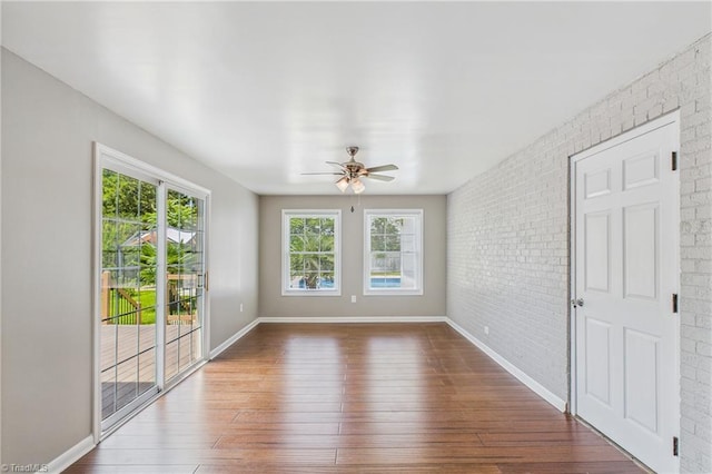 3640 Wyandotte Ave, Winston-Salem, NC 27127 - empty room featuring ceiling fan, dark wood-type flooring, and brick wall