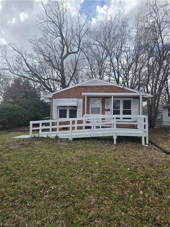 bungalow-style house with brick siding and a front lawn