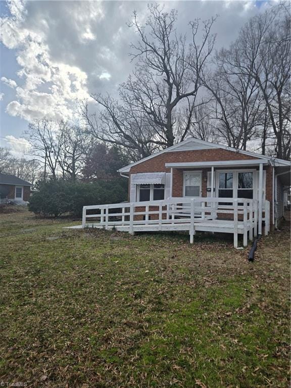 bungalow-style home with brick siding, a shingled roof, a front yard, and fence