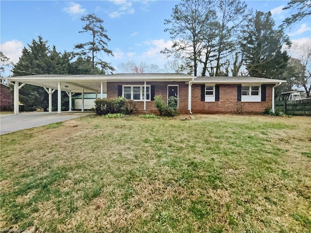 ranch-style house with driveway, an attached carport, fence, a front yard, and brick siding