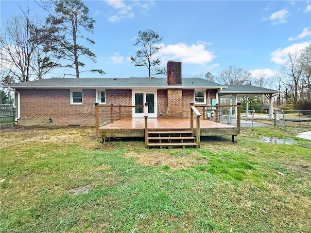 back of house with brick siding, a chimney, fence, and a lawn