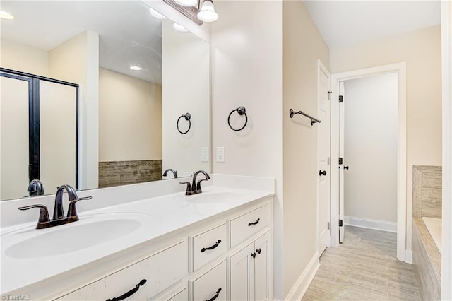 bathroom featuring vanity and a relaxing tiled tub