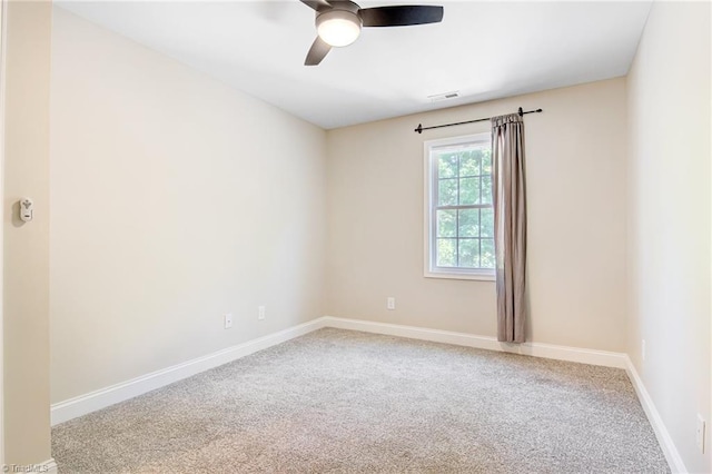 carpeted spare room with ceiling fan