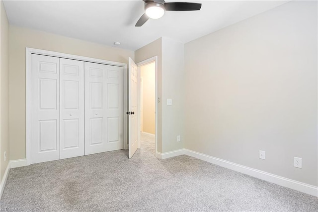 unfurnished bedroom with ceiling fan, light carpet, and a closet