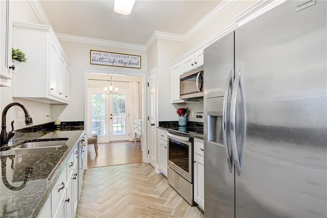 kitchen featuring stainless steel appliances, light parquet floors, dark stone countertops, and sink