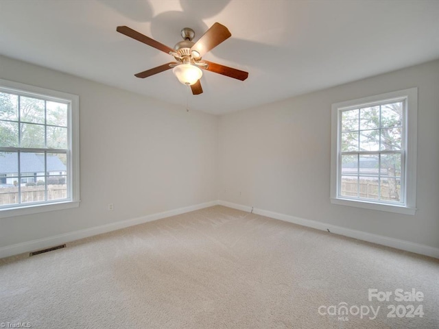 spare room featuring light carpet and ceiling fan