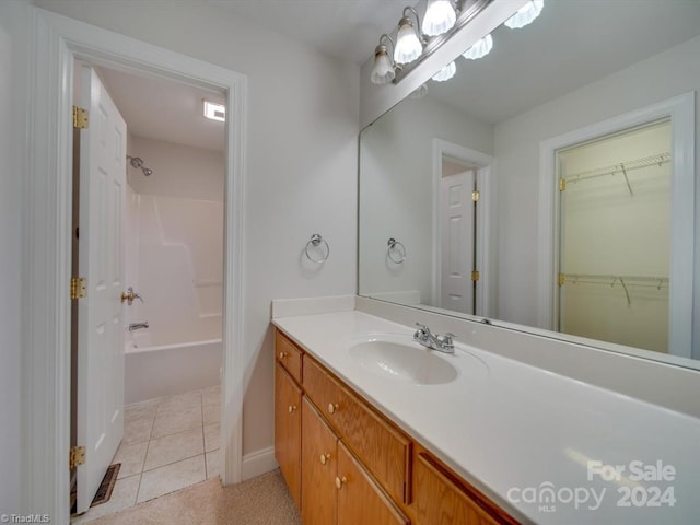 bathroom with vanity, tile patterned floors, and shower / washtub combination