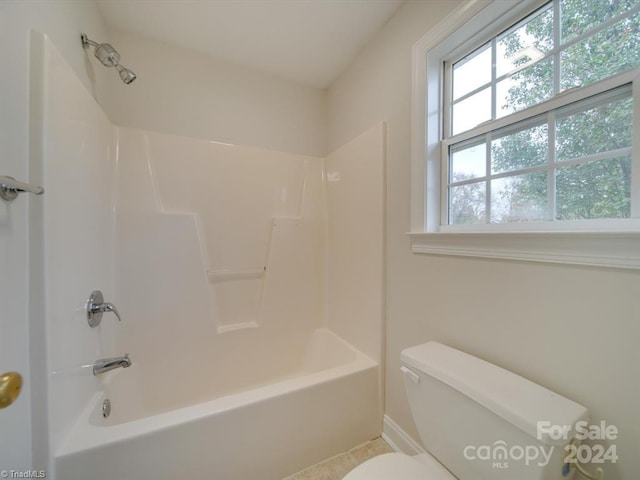 bathroom featuring tile patterned flooring, shower / bathing tub combination, and toilet