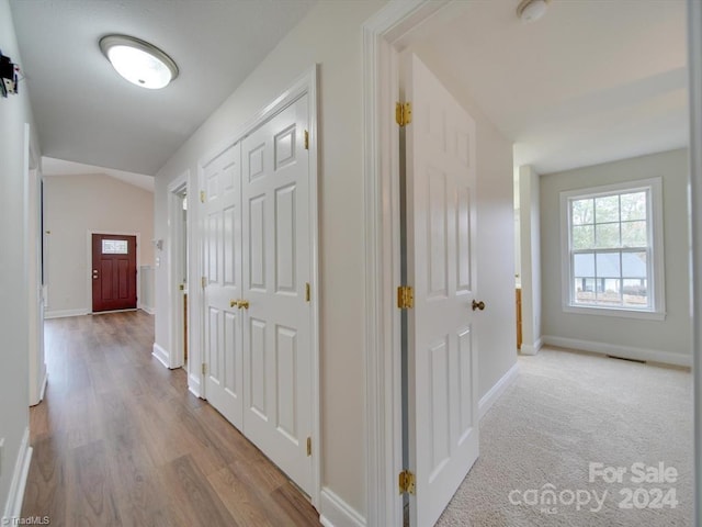 corridor featuring light hardwood / wood-style floors and vaulted ceiling