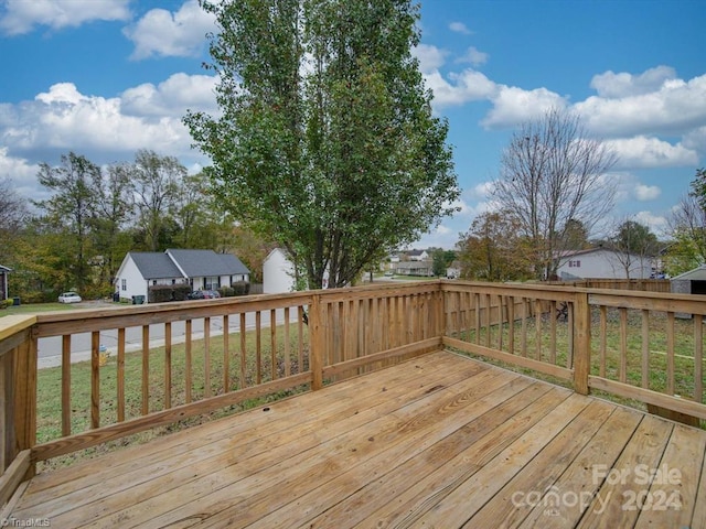 wooden deck featuring a lawn