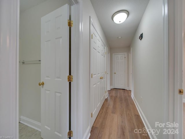 corridor with light hardwood / wood-style floors