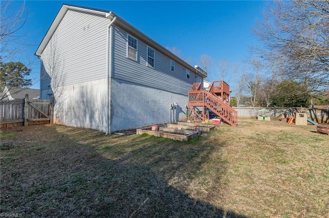 back of property with a playground, stairs, fence, and a lawn