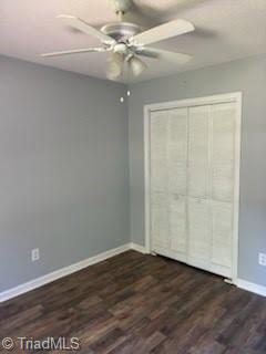 3569 Merry Ridge Rd, Tobaccoville, NC 27050 - unfurnished bedroom with dark wood-style floors, baseboards, a closet, and a ceiling fan