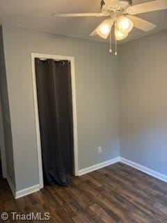 3569 Merry Ridge Rd, Tobaccoville, NC 27050 - unfurnished bedroom with dark wood-style flooring, baseboards, and a ceiling fan
