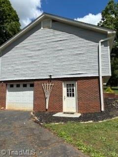 3569 Merry Ridge Rd, Tobaccoville, NC 27050 - view of front facade with brick siding, a garage, and driveway