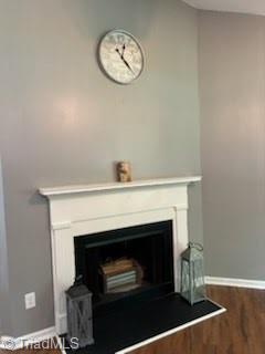 3569 Merry Ridge Rd, Tobaccoville, NC 27050 - detailed view of wood finished floors, a fireplace, and baseboards