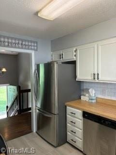 3569 Merry Ridge Rd, Tobaccoville, NC 27050 - kitchen featuring appliances with stainless steel finishes, white cabinets, light countertops, and tasteful backsplash